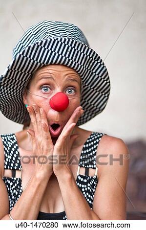 Stock Image - Woman with clown nose making faces. Fotosearch