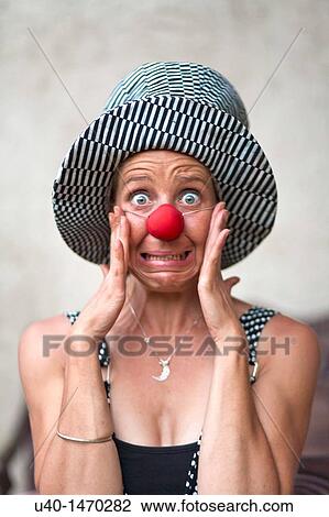 Stock Image - Woman with clown nose making faces. Fotosearch