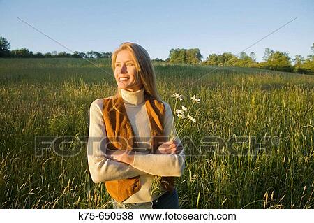 Stock Photo - woman with daisies in field. Fotosearch