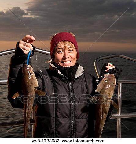 Stock Image - Woman with freshly caught cod, North Atlantic, Raufarhofn, Iceland. Fotosearch