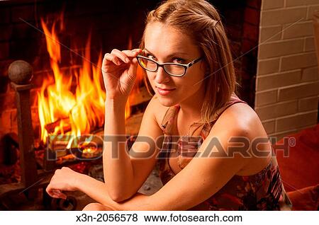 Woman with glasses relaxing on floor by fireplace. View Large Photo Image Stock Photo - Woman with glasses relaxing on floor by fireplace.. Fotosearch