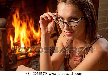 Woman with glasses relaxing on floor by fireplace. View Large Photo Image Stock Photo - Woman with glasses relaxing on floor by fireplace.. Fotosearch