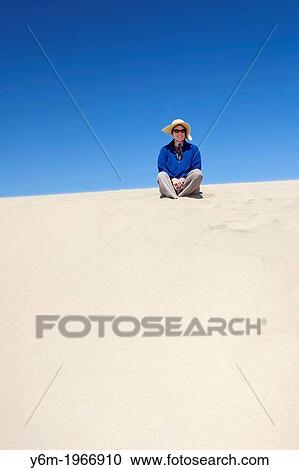 Woman with hat sitting on a sand dune, Florence, Oregon. View Large Photo Image Stock Image - Woman with hat sitting on a sand dune, Florence, Oregon.. Fotosearch