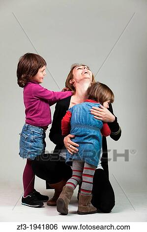 Stock Photograph - Woman with his two daughters in a hug.. Fotosearch