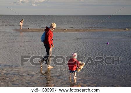 Stock Photo - Woman with Kid in Red on P? rnu Beach in Estonia, Europe. Fotosearch
