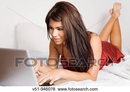 Woman with laptop in bed View Large Photo Image Stock Photo - Woman with laptop in bed. Fotosearch