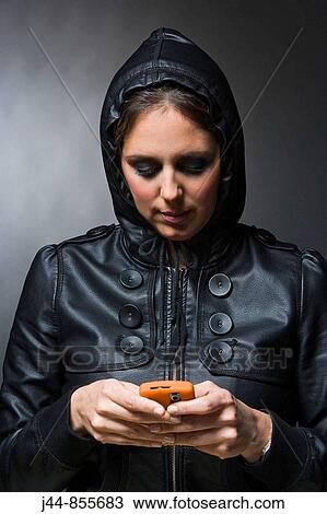 Woman with leather jacket and hood using mobile phone View Large Photo Image Stock Image - Woman with leather jacket and hood using mobile phone. Fotosearch