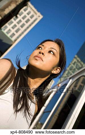 Woman with long brown hair and white top looks off to the left before boarding a bus in the city. Boston, Massachusetts, USA View Large Photo Image Stock Image - Woman with long brown hair and white top looks off to the left before boarding a bus in the city. Boston, Massachusetts, USA. Fotosearch