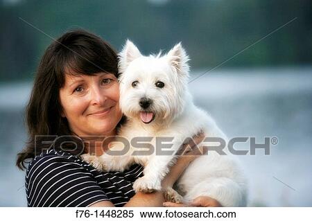 Woman with long dark hair holding her old, white, West Highland Terrier dog View Large Photo Image Stock Photography - Woman with long dark hair holding her old, white, West Highland Terrier dog. Fotosearch