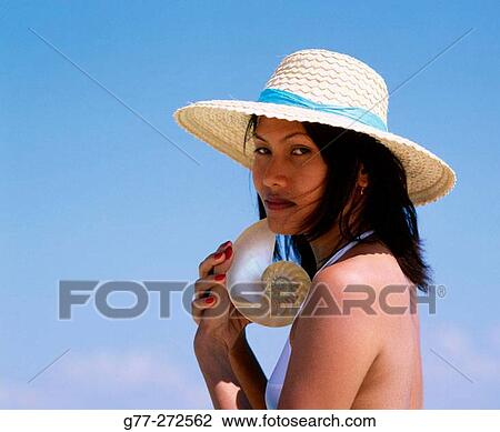 Stock Image - Woman with nautilus half shell. Koh Mor Island. Krabi. Thailand. Fotosearch