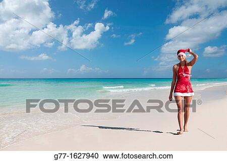 Stock Image - Woman with Santa's hat on the beach, Miami, Florida, USA. Fotosearch