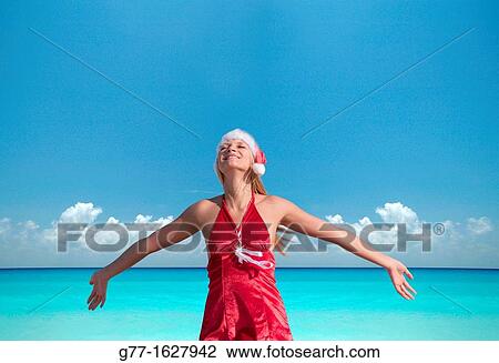 Stock Image - Woman with Santa's hat on the beach, Miami, Florida, USA. Fotosearch