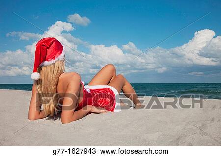 Stock Image - Woman with Santa's hat on the beach, Miami, Florida, USA. Fotosearch