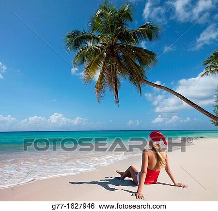 Stock Photograph - Woman with Santa's hat on the beach, Miami, Florida, USA. Fotosearch