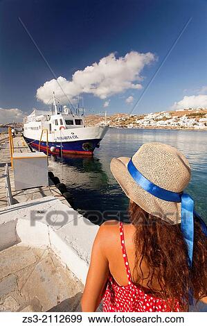 Stock Photo - Woman with straw hat at the old harbour, Mykonos, Cyclades Islands, Greek Islands, Greece, Europe.. Fotosearch