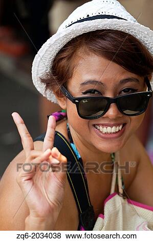 Stock Photo - Woman with Straw Hat in Bangkok.. Fotosearch