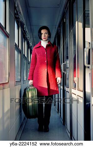 Woman with suitcase standing inside train View Large Photo Image Stock Image - Woman with suitcase standing inside train. Fotosearch
