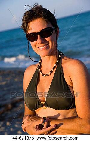 Woman with sunglasses and bathing suit smiling at the beach, Portrait, Hollywood, Florida, USA View Large Photo Image Stock Photography - Woman with sunglasses and bathing suit smiling at the beach, Portrait, Hollywood, Florida, USA. Fotosearch