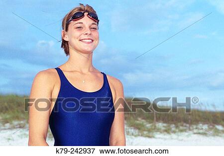 Stock Photo - Woman with Swimsuit and Goggles on Beach Smiling. Fotosearch