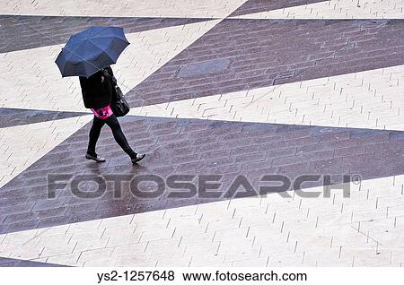 Stock Photo - Woman with umbrella at Sergels Torg in the center of Stockholm, Sweden, Europe. Fotosearch