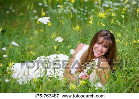 Woman with wildflower bouquet in meadow View Large Photo Image Stock Photo - Woman with wildflower bouquet in meadow. Fotosearch