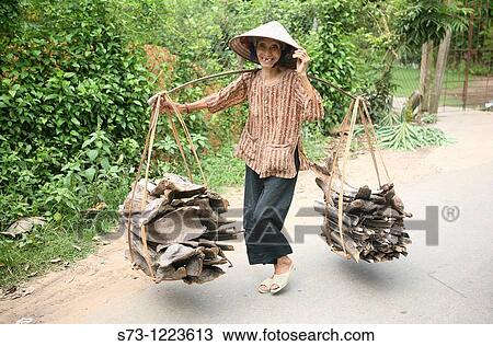 Stock Image - Woman with wood in My Duc, Vietnam. Fotosearch