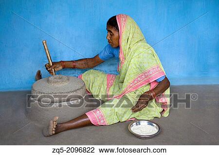Stock Image - Woman working on a grinding stone, Gadchiroli, Maharashtra, India.. Fotosearch