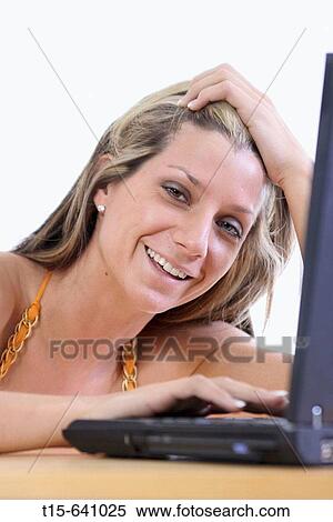 Woman working on her laptop having fun View Large Photo Image Stock Photography - Woman working on her laptop having fun. Fotosearch