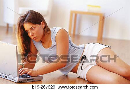 Woman working with a portable computer on the floor View Large Photo Image Stock Photo - Woman working with a portable computer on the floor. Fotosearch