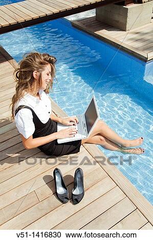Woman working with laptop by the pool View Large Photo Image Stock Image - Woman working with laptop by the pool. Fotosearch