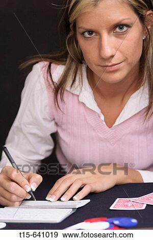 Stock Photo - Woman writing a check in the midst of a card game. Fotosearch