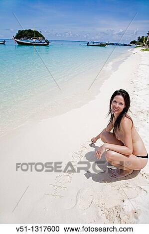 Woman writing in the sand at a paradise beach in Koh Lipe, Thailand View Large Photo Image Stock Image - Woman writing in the sand at a paradise beach in Koh Lipe, Thailand. Fotosearch