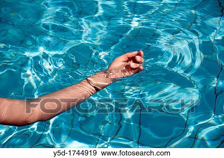 Stock Photo - Woman's hand in swimming pool. Fotosearch