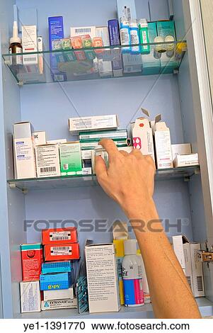 Woman's hand taking medicine from a cupboard fill of prescription drugs and pharmaceuticals View Large Photo Image Stock Image - Woman's hand taking medicine from a cupboard fill of prescription drugs and pharmaceuticals. Fotosearch