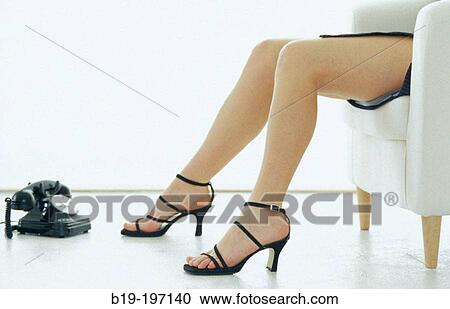Stock Image - Woman's legs, old telephone. Fotosearch