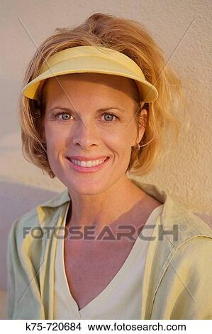 Picture - Woman's portrait outdoors wearing visor. Fotosearch