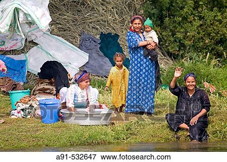 Stock Photo - Women and children washing laundry and bathing. River Nile between Qena and Luxor. Upper Egypt. Fotosearch