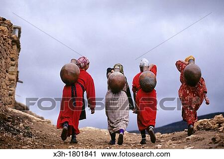 women carrying water in jar on their back from spring to the village Imi n Tala, High Atlas, Morocco, North Africa View Large Photo Image Stock Image - women carrying water in jar on their back from spring to the village Imi n Tala, High Atlas, Morocco, North Africa. Fotosearch