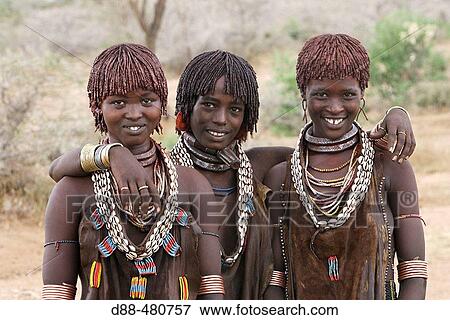 Stock Photo - Women Hamer tribe. Lower basin of Omo river. Copper skin with very fine features and wear metal arm and leg bracelets, shells and beads. South Ethiopia.. Fotosearch