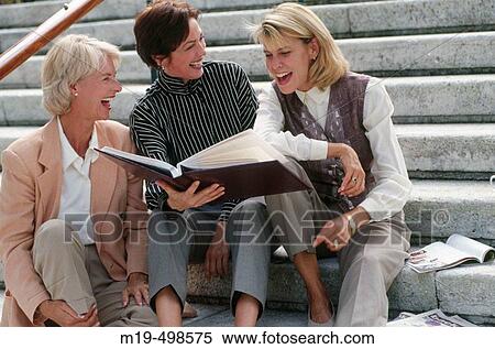 women looking at a picture album View Large Photo Image Stock Photography - women looking at a picture album. Fotosearch