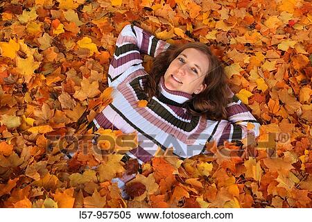 women lying in pile of leaves, fall Zuerich, Switzerland View Large Photo Image Stock Photography - women lying in pile of leaves, fall Zuerich, Switzerland. Fotosearch
