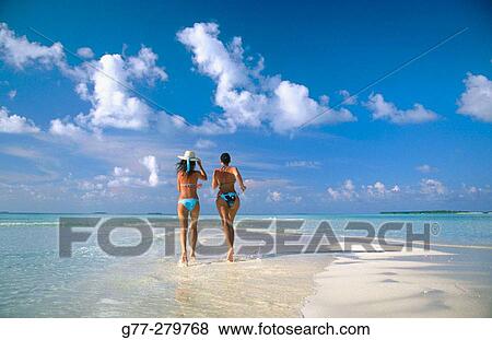 Stock Photo - Women on the beach in Ari Atoll. Maldives. Fotosearch