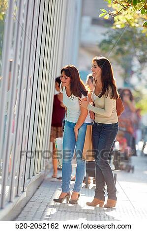 Stock Image - Women sisters 35 and 40 years looking a shop window. Shopping on the street. Donostia. San Sebastian. Gipuzkoa. Basque Country- Spain.. Fotosearch