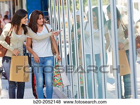 Stock Photo - Women sisters 35 and 40 years looking a shop window. Shopping on the street. Donostia. San Sebastian. Gipuzkoa. Basque Country- Spain.. Fotosearch