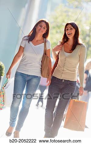 Stock Image - Women sisters 35 and 40 years shopping on the street. Donostia. San Sebastian. Gipuzkoa. Basque Country- Spain.. Fotosearch