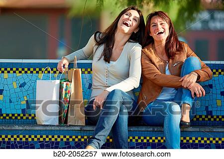 Stock Photo - Women sisters 35 and 40 years shopping on the street. Donostia. San Sebastian. Gipuzkoa. Basque Country. Spain.. Fotosearch