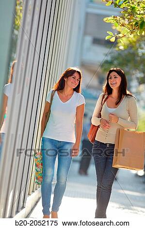 Stock Photography - Women sisters 35 and 40 years shopping on the street. Donostia. San Sebastian. Gipuzkoa. Basque Country- Spain.. Fotosearch