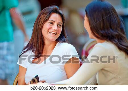 Stock Image - Women sisters 35 and 40 years taking coffee on a terrace. Donostia. San Sebastian. Gipuzkoa. Basque Country- Spain.. Fotosearch
