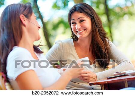 Stock Image - Women sisters 35 and 40 years taking coffee on a terrace. Donostia. San Sebastian. Gipuzkoa. Basque Country- Spain.. Fotosearch