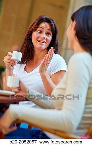 Stock Photo - Women sisters 35 and 40 years taking coffee on a terrace. Donostia. San Sebastian. Gipuzkoa. Basque Country- Spain.. Fotosearch